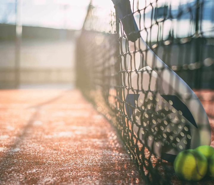 padel-blade-racket-resting-on-the-net-E349XU6